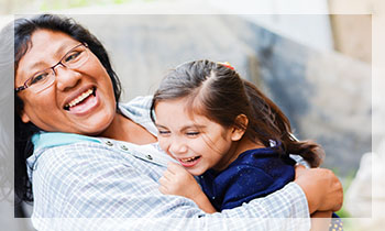 Happy latin mom and little daughter outside.